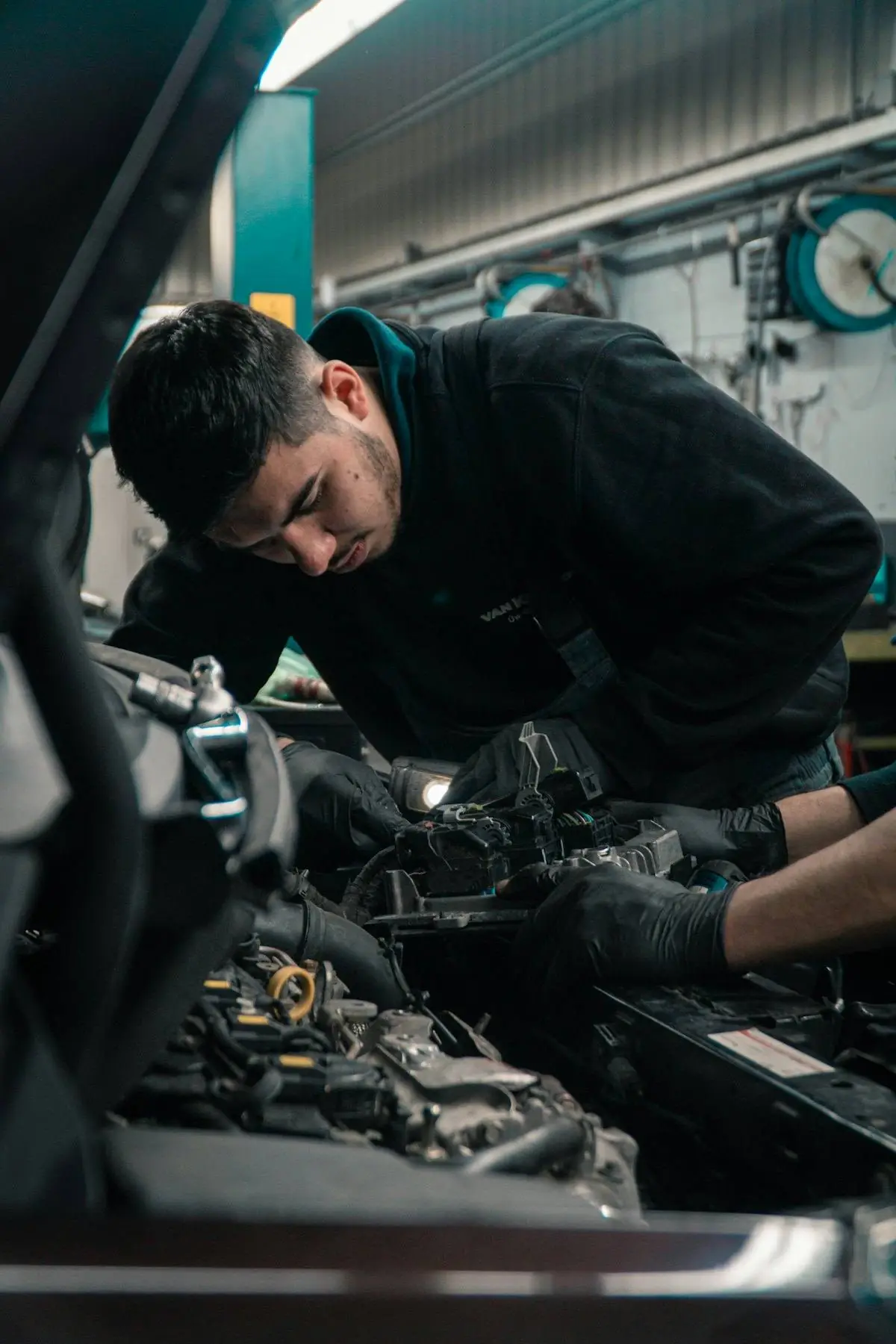 Professionnel automobile inspectant le moteur d'une voiture d'occasion à Saint-Denis